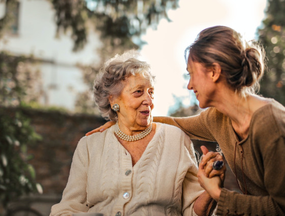 Two women having a conversation and holding hands.