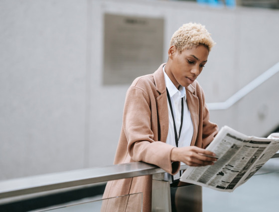 A woman reading a newspaper.