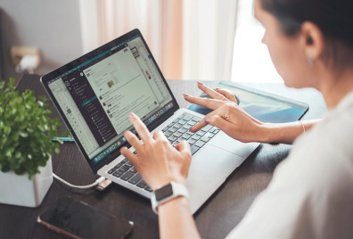 A lady using a laptop sat at a desk