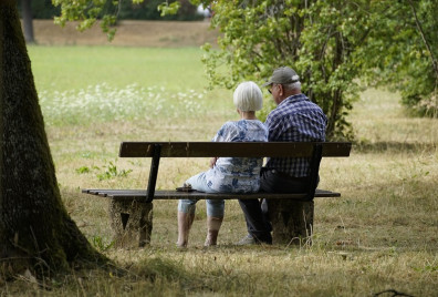 A couple sat on a bench in a park